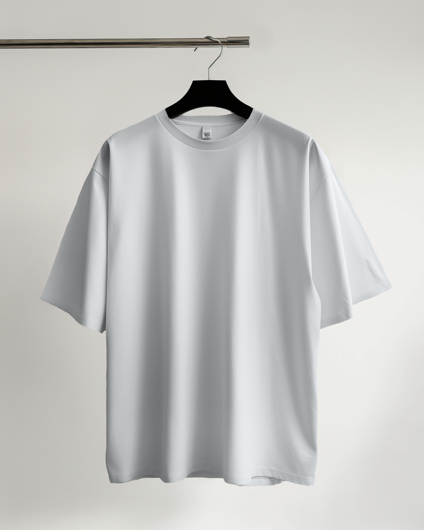 White t-shirt on a hanger against a plain background