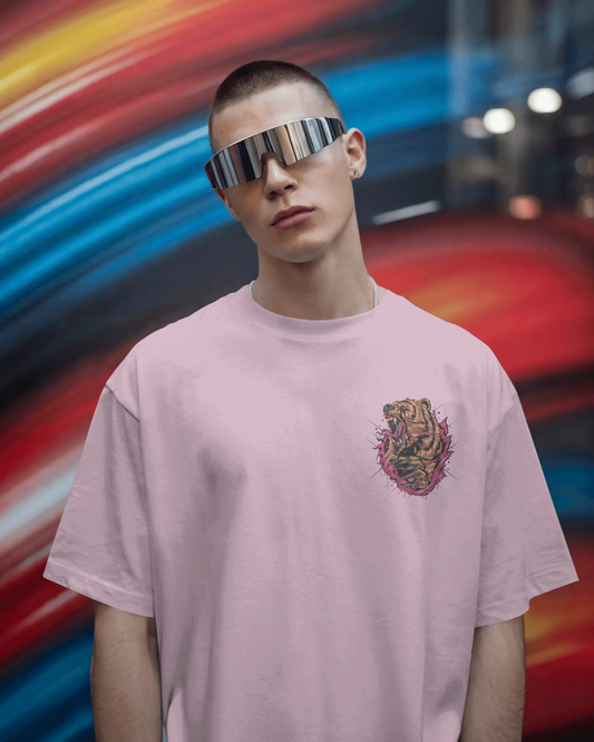 Person wearing a pink t-shirt with a graphic design, standing against a colorful, blurred background.