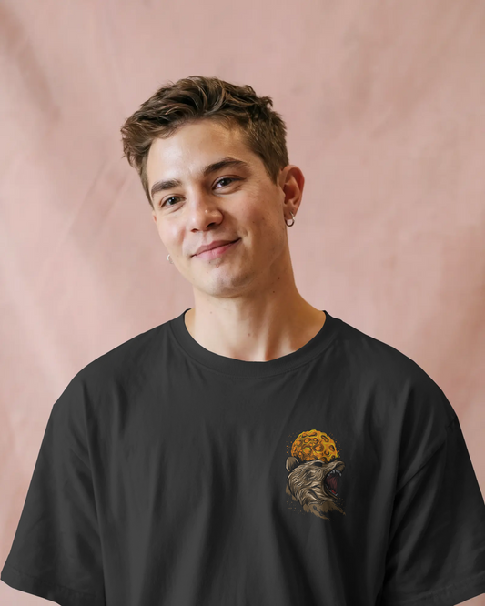 Person wearing a black t-shirt with a graphic design on a pink background