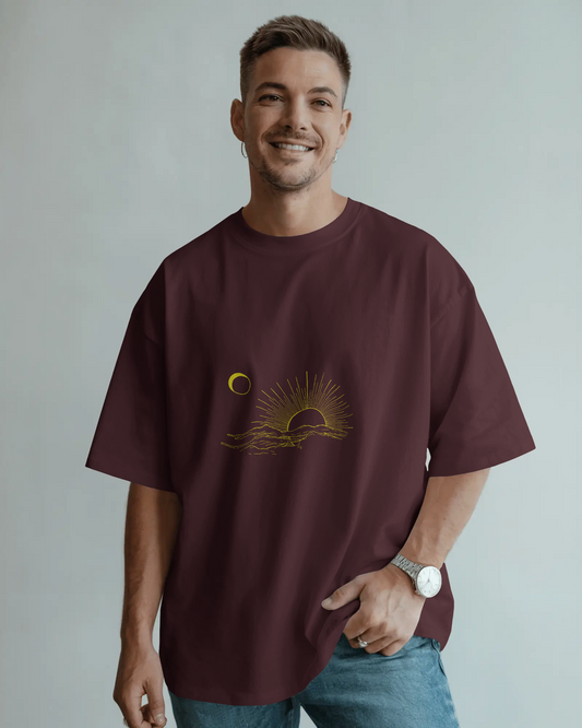 Man wearing a maroon t-shirt with a graphic design on a plain background