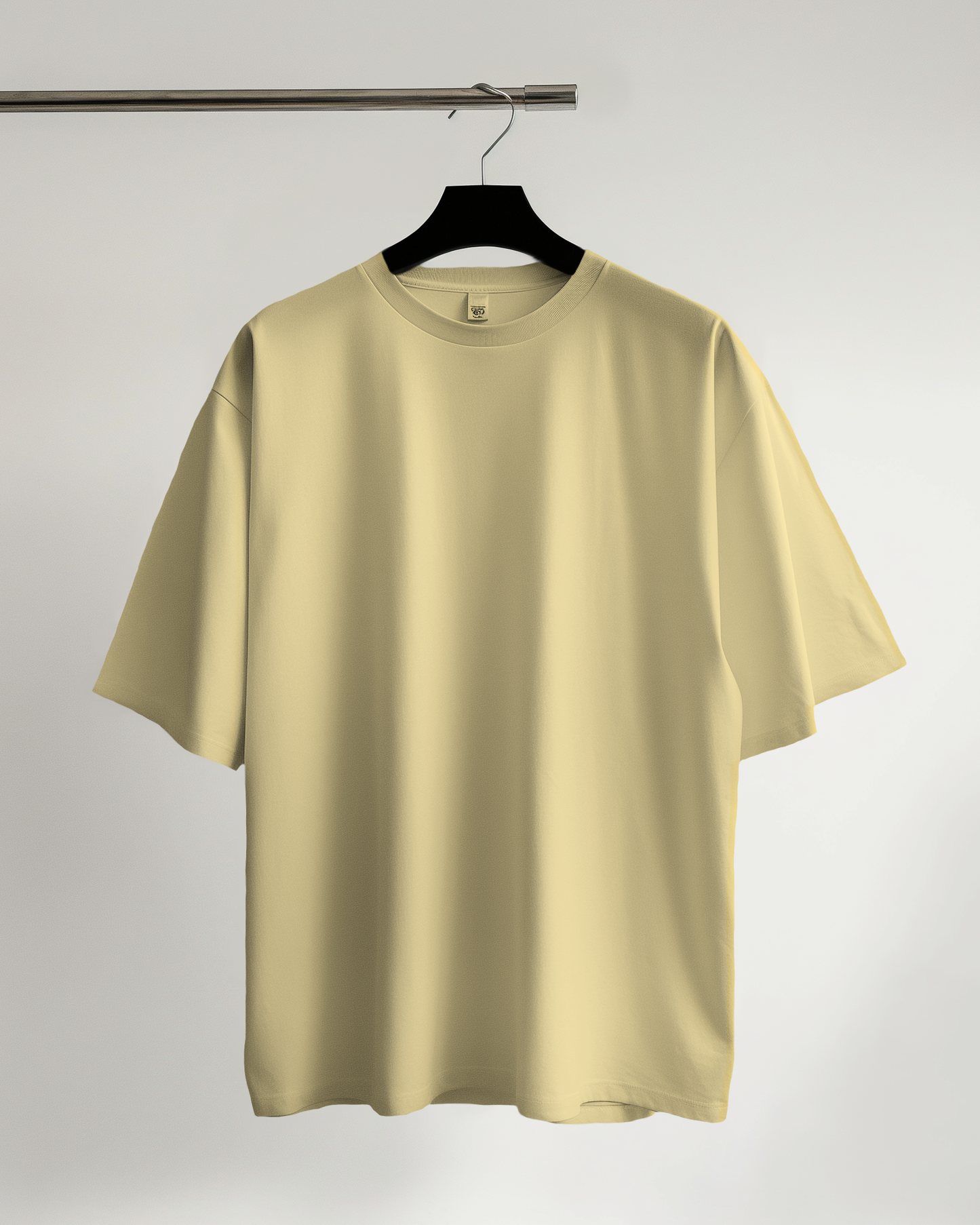 Beige t-shirt on a hanger against a plain background